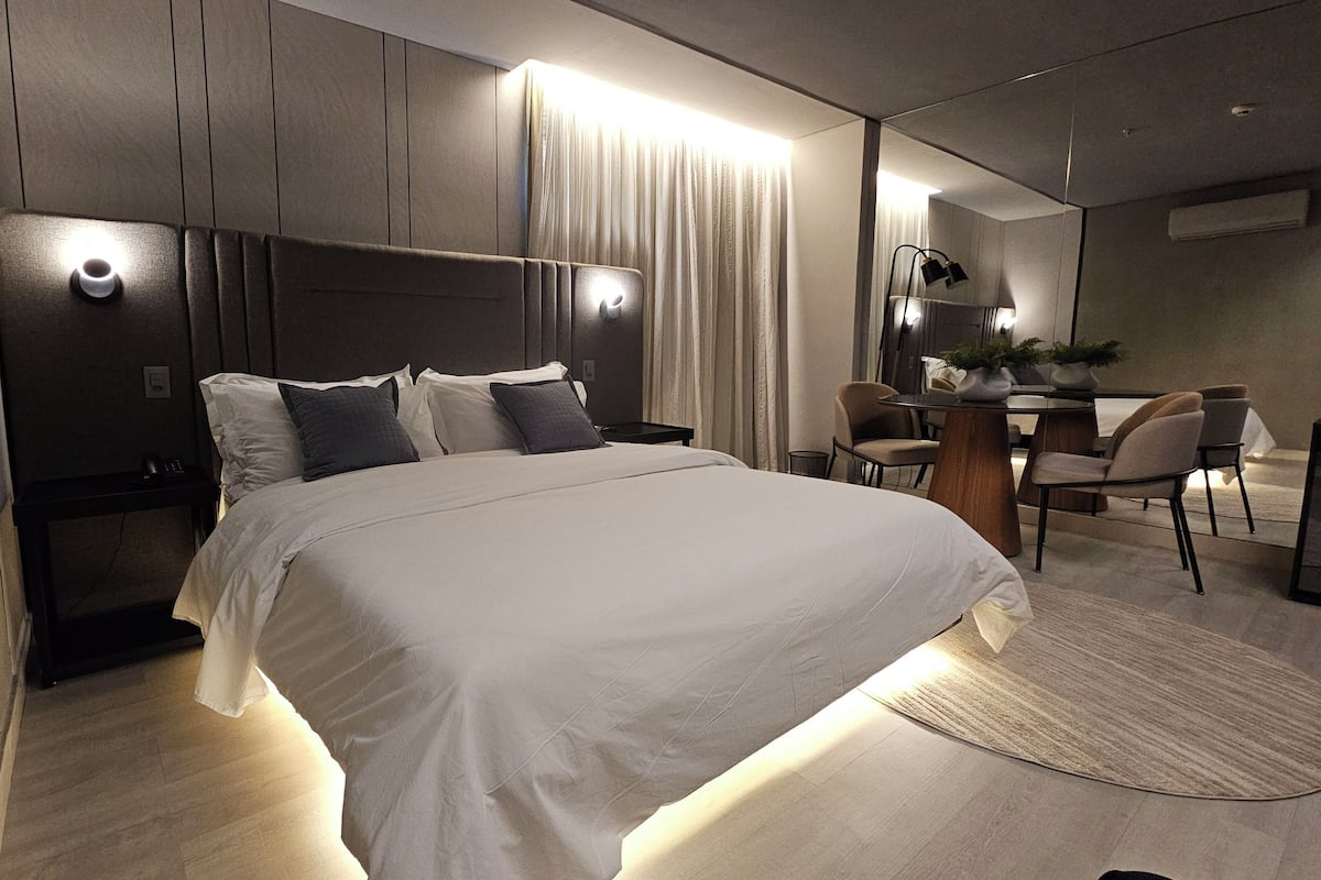 Een moderne hotelkamer met een groot bed, een bureau en een stoel.