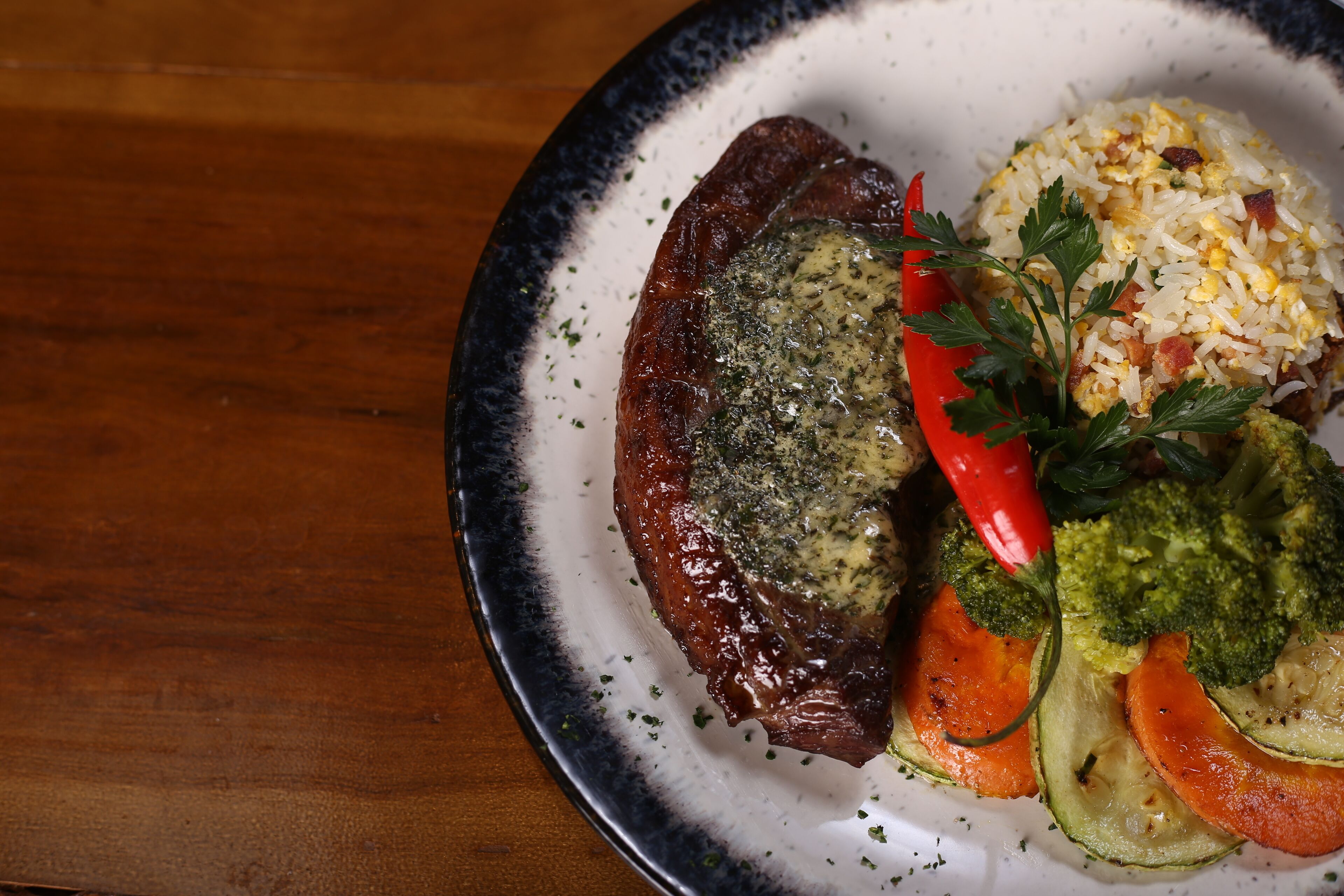 A plate with a steak, rice, and vegetables.