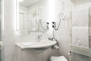 A modern bathroom with a white sink, mirror, and towel rack. - Consulat des Weins (Sankt Martin)