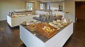 Una mesa de buffet con diversos alimentos y cristalería.