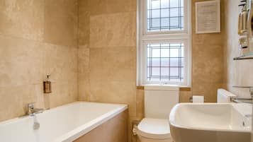 A bathroom with a bathtub, toilet, and sink.