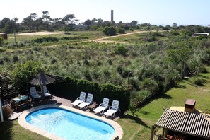 Una piscina al aire libre, tumbonas
