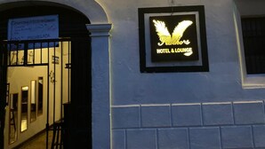 A sign for 'Feathers Hotel & Lounge' with a winged logo. - Feathers Hotel and Lounge - Hostel (Antigua Guatemala)