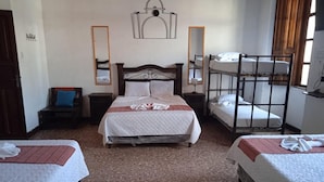 A room with a large bed, two smaller beds, a bunk bed, a chair, and a mirror. - Feathers Hotel and Lounge - Hostel (Antigua Guatemala)