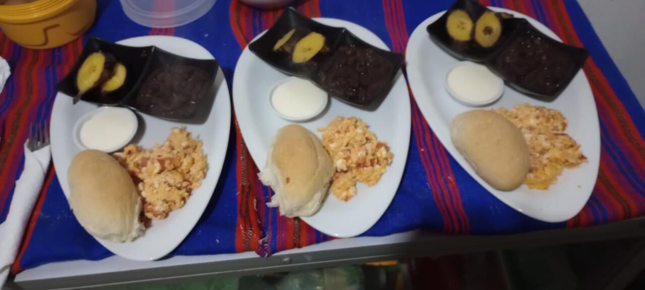 Three plates of food with various dishes including bread, eggs, and beans.