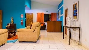 A hotel lobby with a beige sofa, a wooden reception desk, and a tiled floor. - Hotel Fontana (Managua)