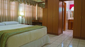 A hotel room with a large bed, a desk, and a wardrobe. - Hotel Fontana (Managua)