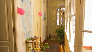 Un pasillo con suelo de madera, una planta y un mapa en la pared.