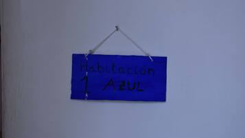 A blue sign with the text "Habitacion Azul" indicating a room color.