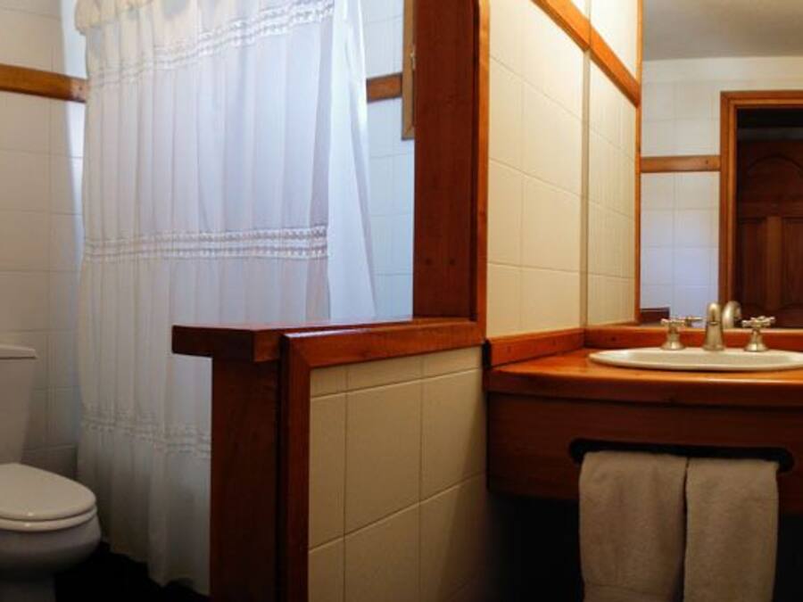 Une salle de bain équipée de toilettes, d’un bidet, d’un lavabo et d’un miroir.