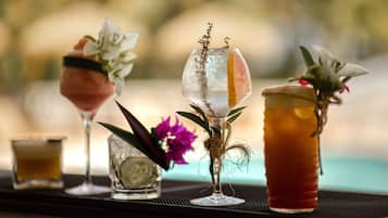 A bar area with various drinks and a small vase with flowers.