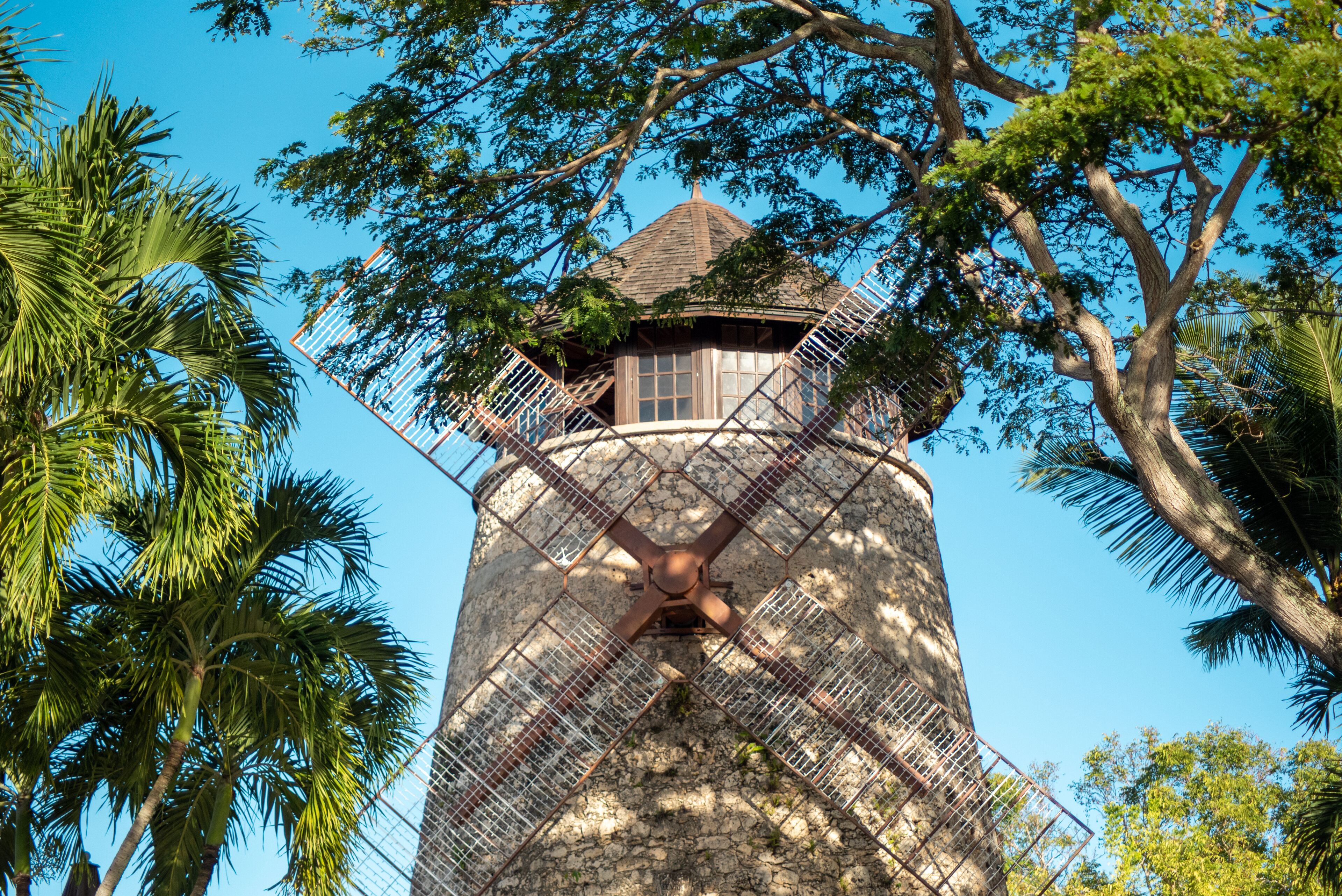 Een windmolen met een houten constructie en een metalen spijlenraster.