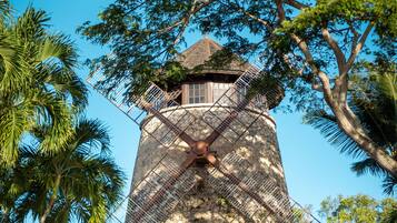 Een windmolen met een houten constructie en een metalen spijlenraster.