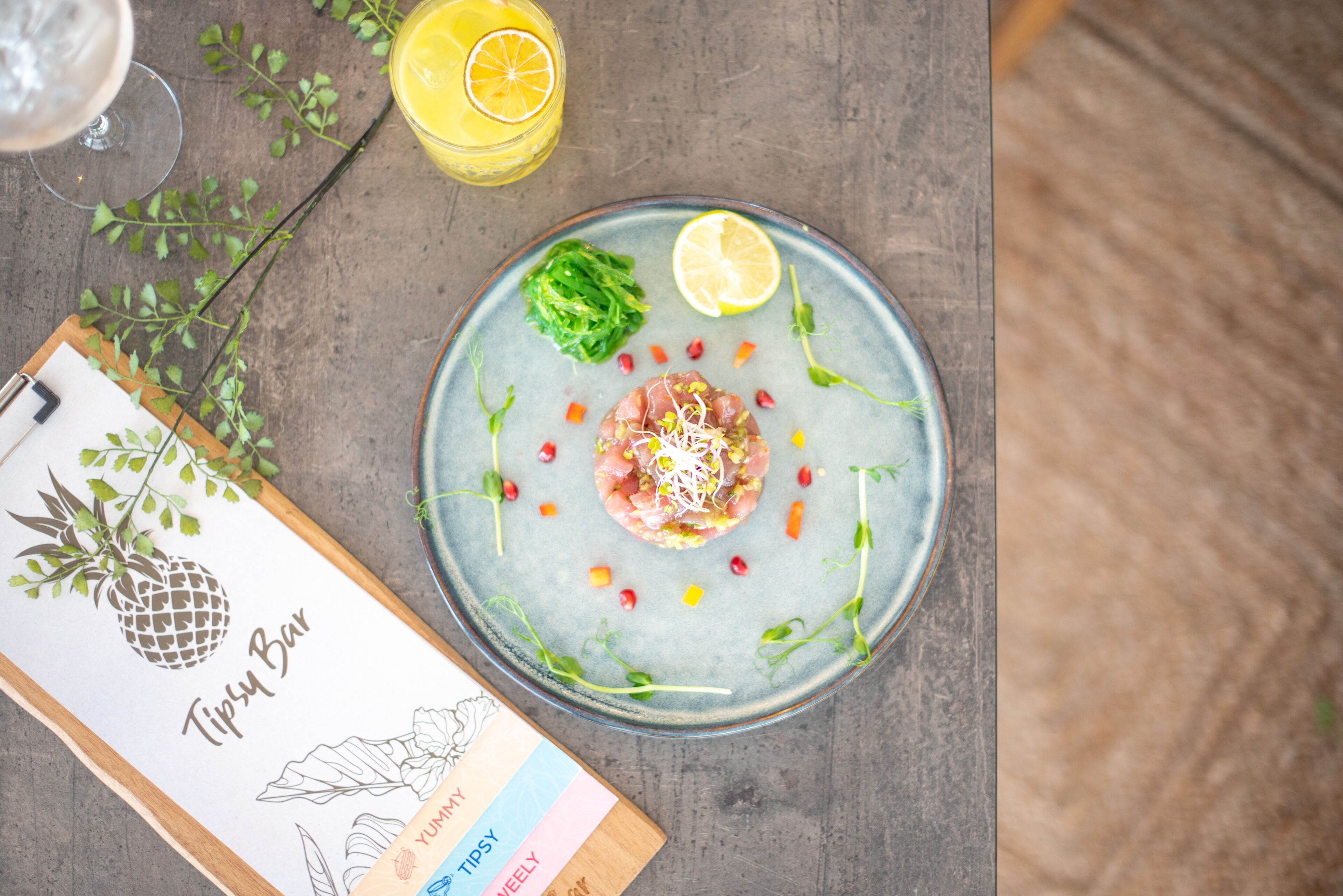 A table with a plate of food, a drink, and a menu.