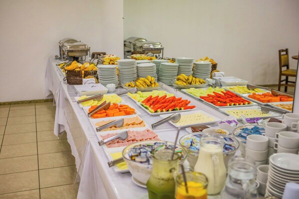 Una mesa de buffet con diversos alimentos y bebidas.