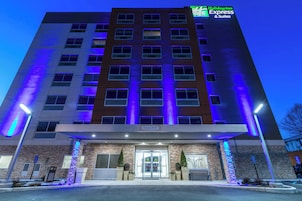 A Holiday Inn Express & Suites building with a clear entrance, a brick facade, and a sign indicating a clearance of 10'-04'.