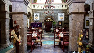 A historic building with stone columns, a central archway, and a chandelier.
