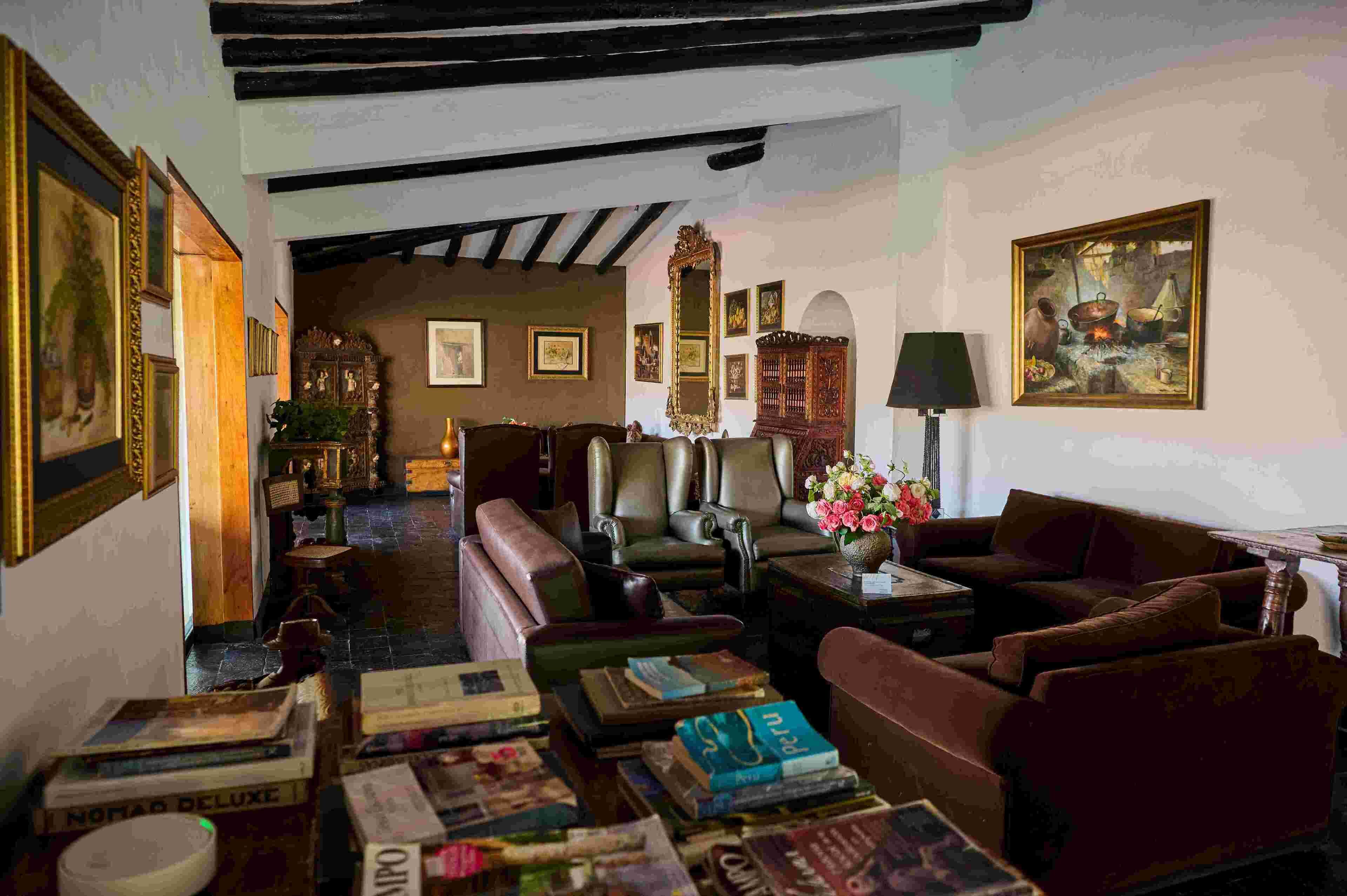 A cozy room with leather sofas, a coffee table, and a bookshelf filled with books.