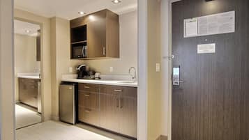A modern kitchen with wooden cabinets, a built-in microwave, and a stainless steel refrigerator.