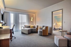 Relax in a spacious room with a large window, comfortable seating area, and a desk for work.
