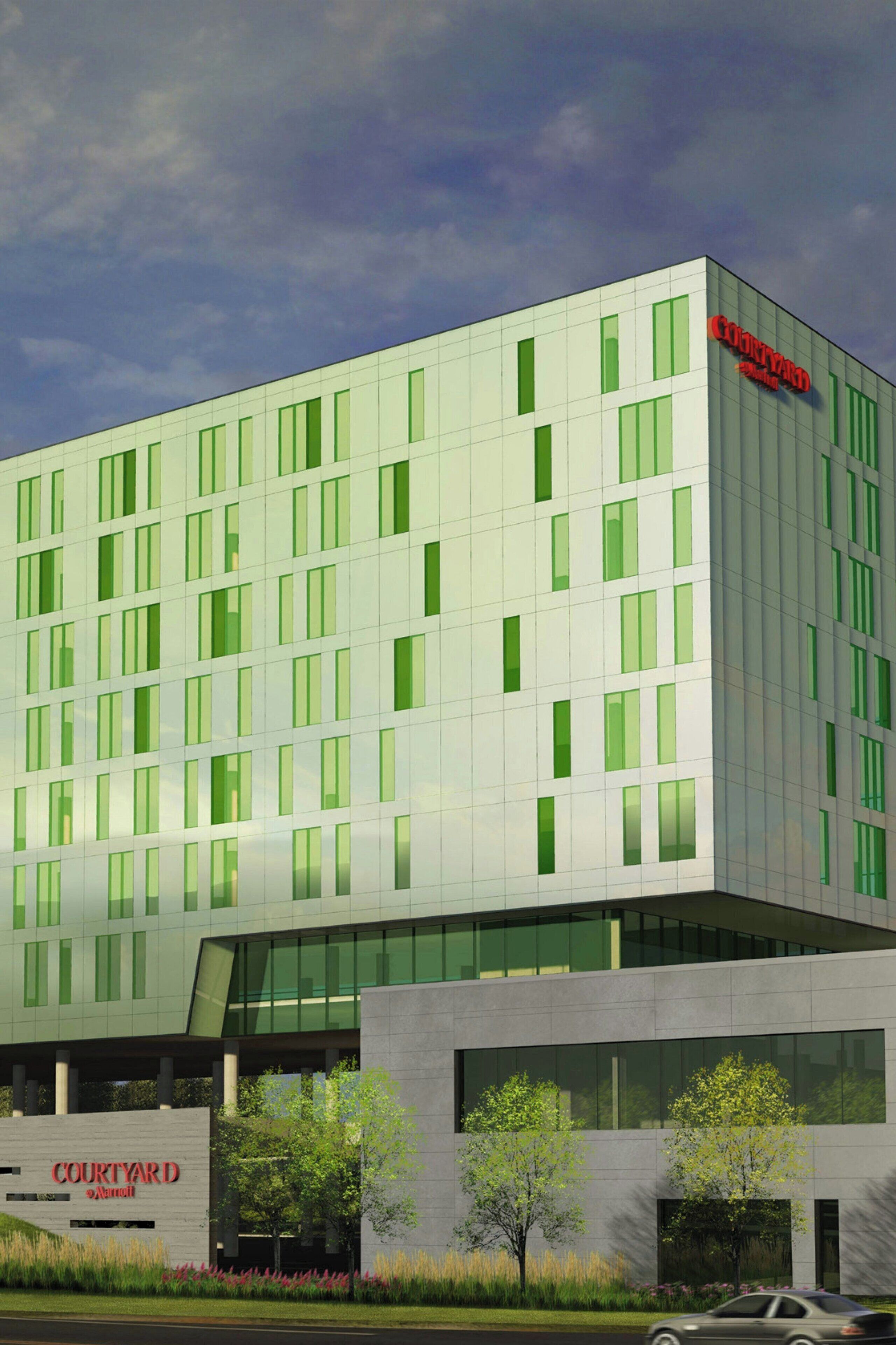 A modern hotel building with a glass facade, labeled "Courtyard by Marriott."