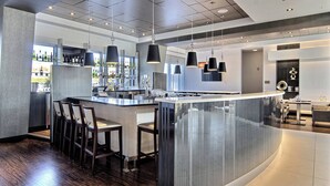 Una cocina moderna con una isla central, barra y asientos.