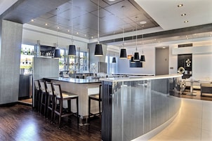 Una cocina moderna con una isla central, barra y asientos.