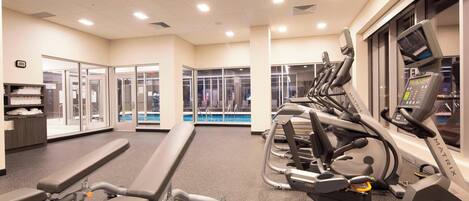 A gym with treadmills, stationary bikes, and weight machines.