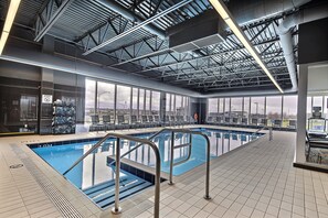 Relax by the pool with a clear view of the sky through large windows, featuring a changing room and comfortable seating area.