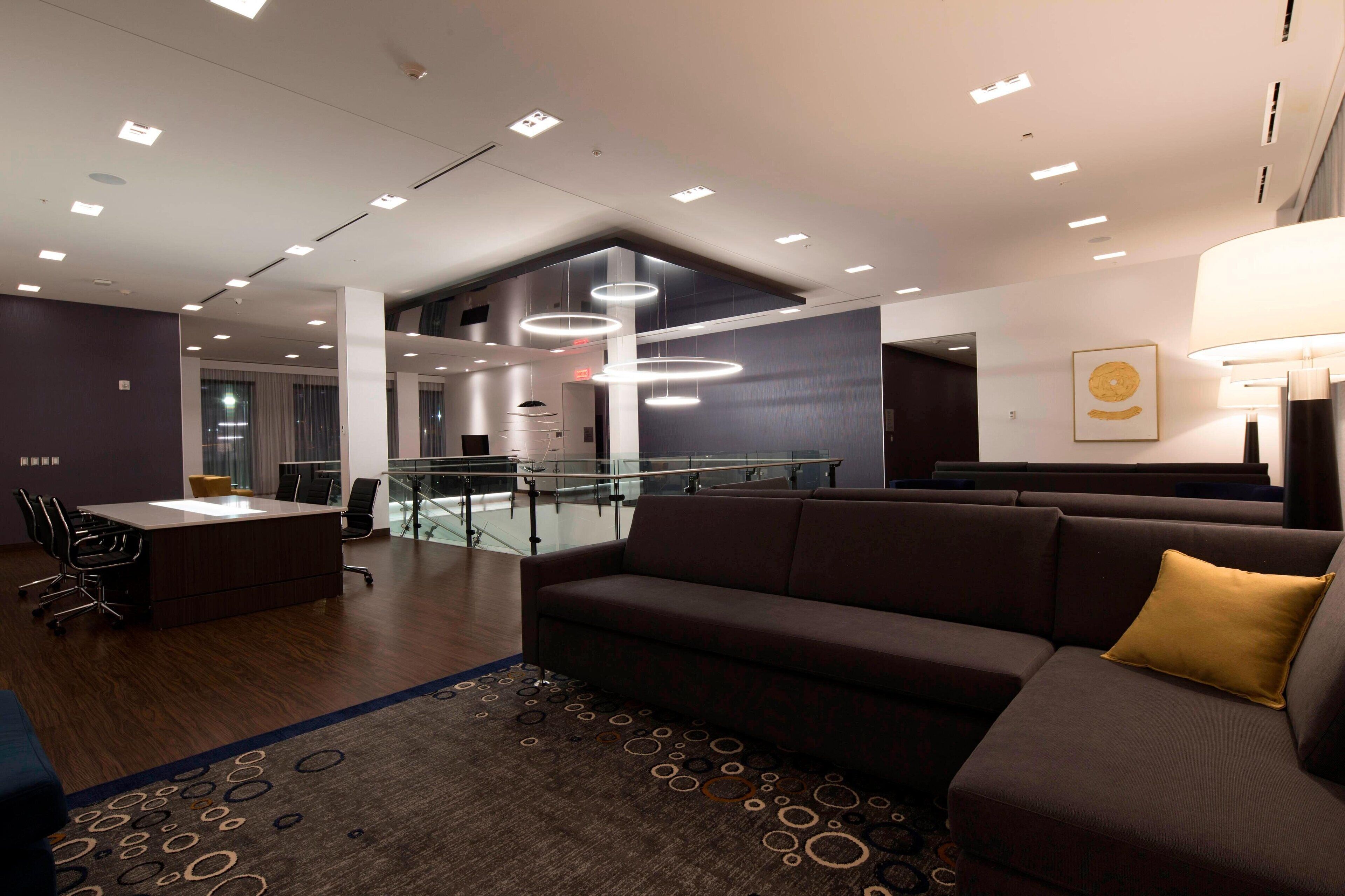 A modern office space with a reception desk, a sofa, and a patterned rug.