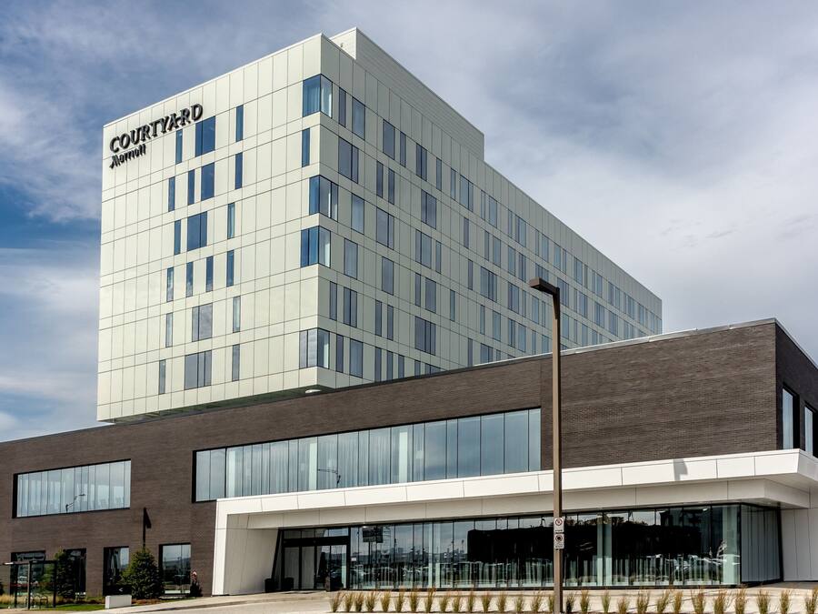 Een modern hotelgebouw met een opvallend 'Courtyard' bord, grote ramen en een plat dak.