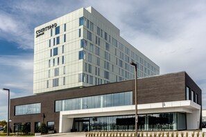 Experience the modern design of this hotel, featuring a prominent white facade and large windows with expansive views.