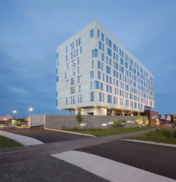 A modern multi-story hotel with a flat roof, large windows, and a parking area in front. - Courtyard by Marriott Quebec City (Québec City)