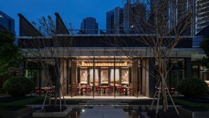 Un edificio moderno con zona de comedor y piscina.