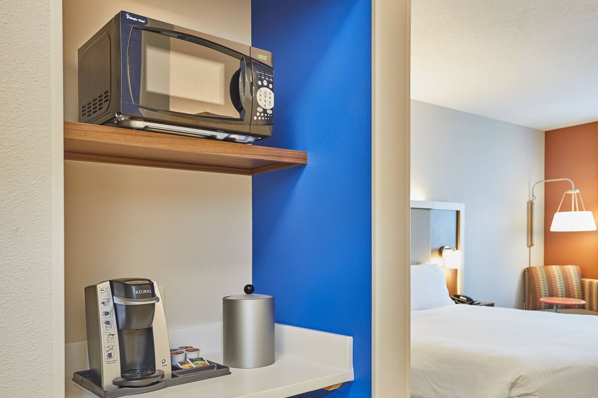 A compact kitchenette with a microwave, coffee maker, and mini-fridge.