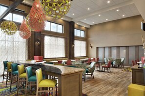 Enjoy dining and socializing in this inviting space with a curved bar, high-top tables, and comfortable seating.