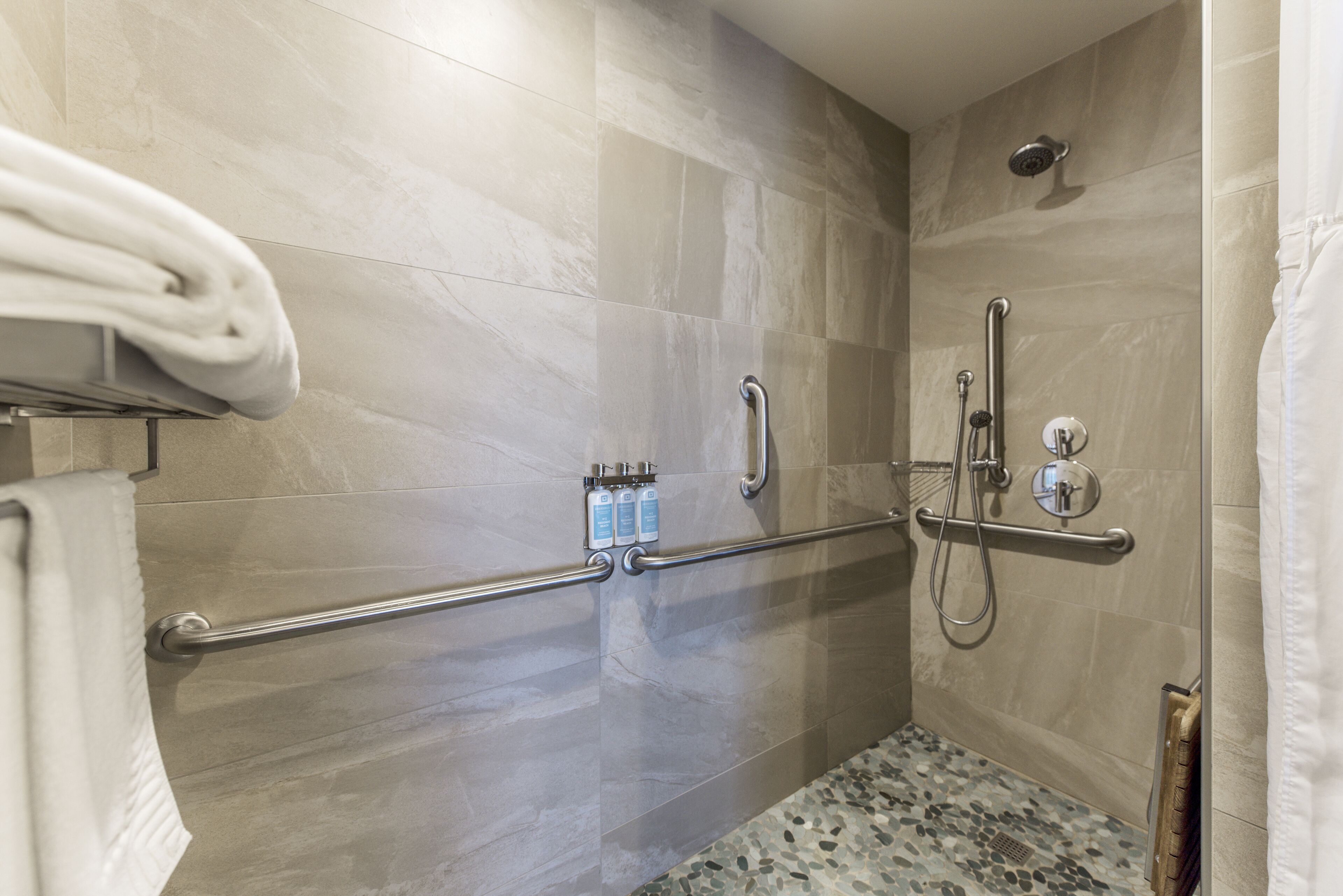 Eine Dusche mit Haltegriffen und Duschbrause.