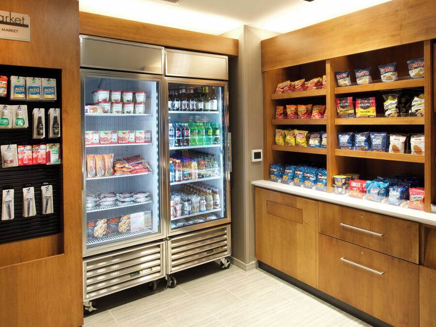 Ein Vorratsschrank mit Snacks und Getränken, darunter verpackte Snacks auf einem Regal und ein Bereich mit abgefüllten Getränken.
