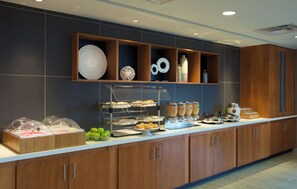 A buffet area with various food items and a display of decorative plates. - SpringHill Suites by Marriott Seattle Issaquah (Issaquah)