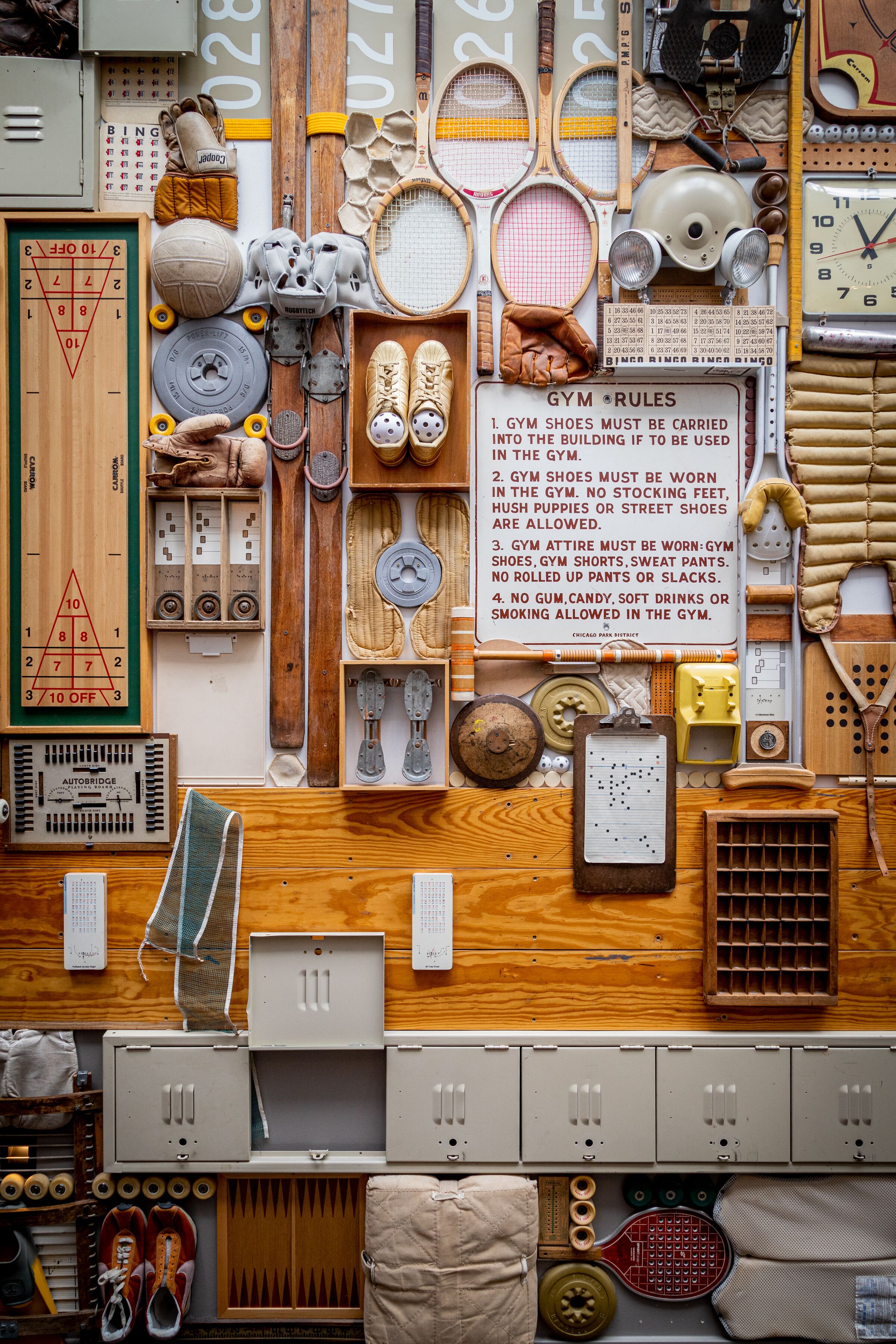 A wall filled with various sports equipment and gym rules.