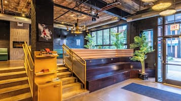 Een modern interieur met een trap, een bankje en uitzicht op het omliggende landschap.