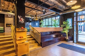 A modern interior with a staircase, a bench, and a view of the outside. - The Chicago Hotel Collection River North (Chicago)
