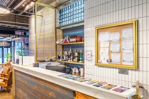 A reception desk with a bulletin board displaying various notices and a shelf with trophies and sports equipment. - The Chicago Hotel Collection River North (Chicago)