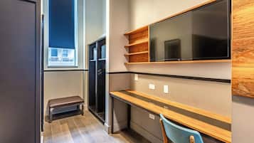 Una cocina moderna con microondas integrado, estanterías de madera, un banco y un ventanal grande.