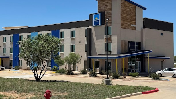 A modern hotel with a flat roof, a blue and beige color scheme, and a sign indicating it is a Days Inn. - Days Inn & Suites by Wyndham Colorado City/I-20 (Colorado City)