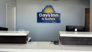 A reception desk area with a sign for Days Inn & Suites by Wyndham, a computer monitor, a phone, and a direct TV sign. - Days Inn & Suites by Wyndham Colorado City/I-20 (Colorado City)