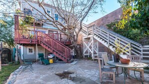 A patio area with stone flooring, outdoor furniture, and a staircase leading to a balcony. - Stunning 1 Bedroom Flat (Oakland)