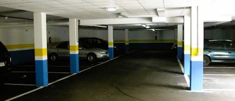 A multi-level parking garage with white pillars and blue and yellow stripes.