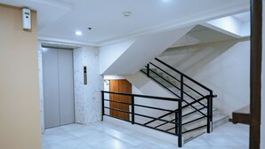 Un interior moderno con una escalera, una puerta y un accesorio de iluminación.