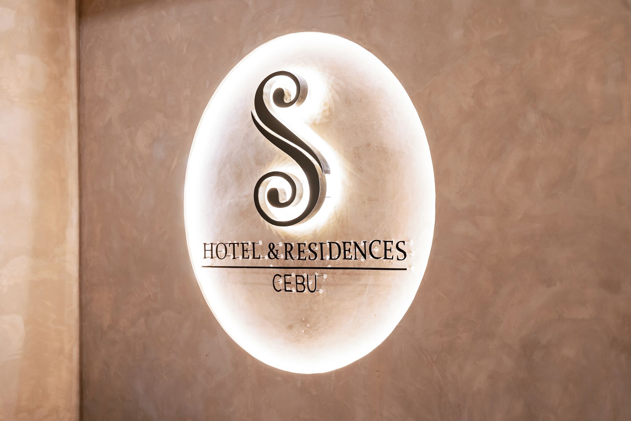 A sign with a stylized 'S' logo and the text 'HOTEL & RESIDENCES CEBU'.